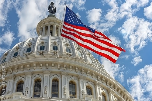 Close up view of the capitol s white dome with an american flag against a clear blue sky