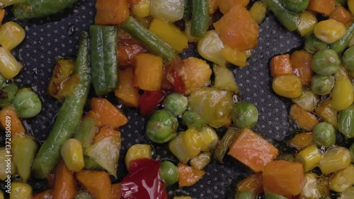 A mixture of frozen vegetables lies in a frying pan, top view.
