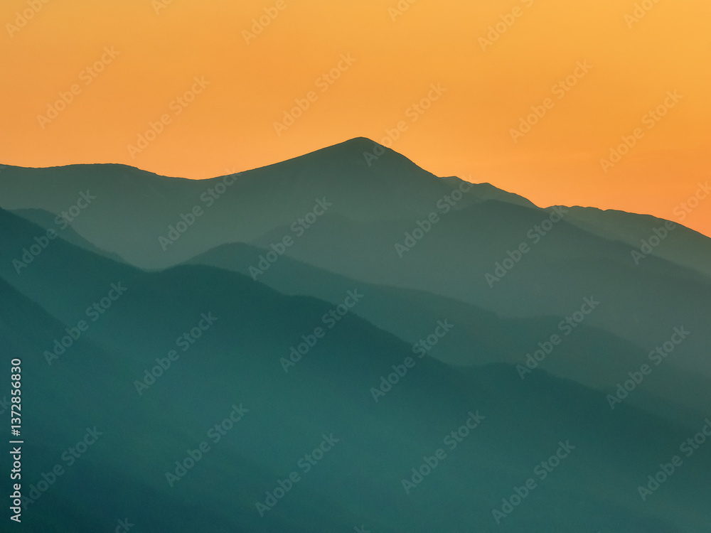 Obraz premium Drone view over Pirin Mountains, Bulgaria, during silhouette summer sunset, silhouettes of ridges blending into warm horizon, peaceful natural beauty of Balkan landscape. Travel, tourism