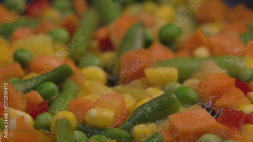A mixture of frozen vegetables lies in a frying pan, top view.
