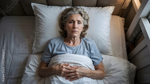 Senior woman lying in bed awake and suffering from insomnia