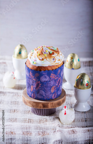 Obraz na płótnie Easter cake, chocolate eggs in gold foil and chicken-shaped candles on a light background. w salonie