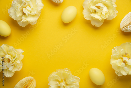 Happy Easter holiday background. Easter eggs and tulip flowers on yellow background top view.