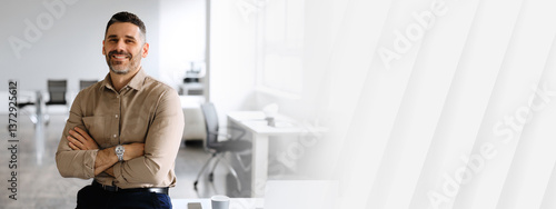 Successful businessman. Confident man in shirt sitting on desk, posing with folded arms, looking and smiling at camera, copy space, place for advertisement