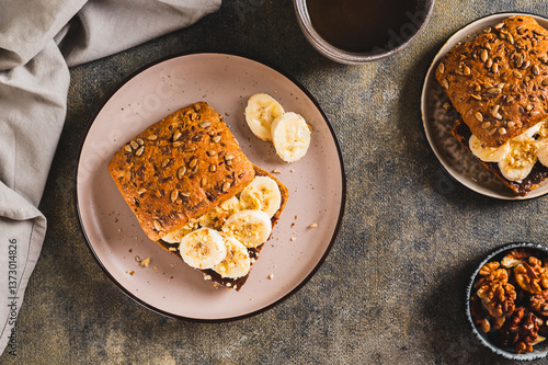 Obraz na płótnie Sweet sandwich with chocolate butter, banana and nuts on a plate on the table top view w salonie