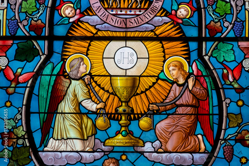 Stained glass (19th century) of Representation of the Eucharist and chalice, symbol of bread and wine surrounded by angels.