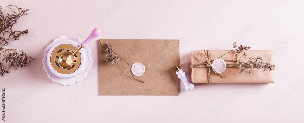 Craft envelope with wax seal and crafting items on pink top view web banner
