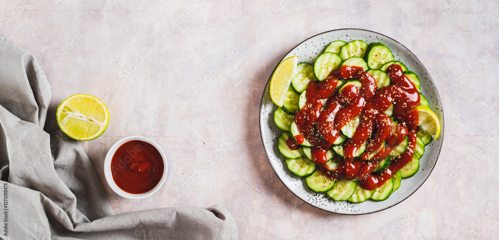 Delicious cucumbers with chili pepper and lime on a plate on the table top view web banner