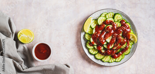 Obraz na płótnie Delicious cucumbers with chili pepper and lime on a plate on the table top view web banner w salonie