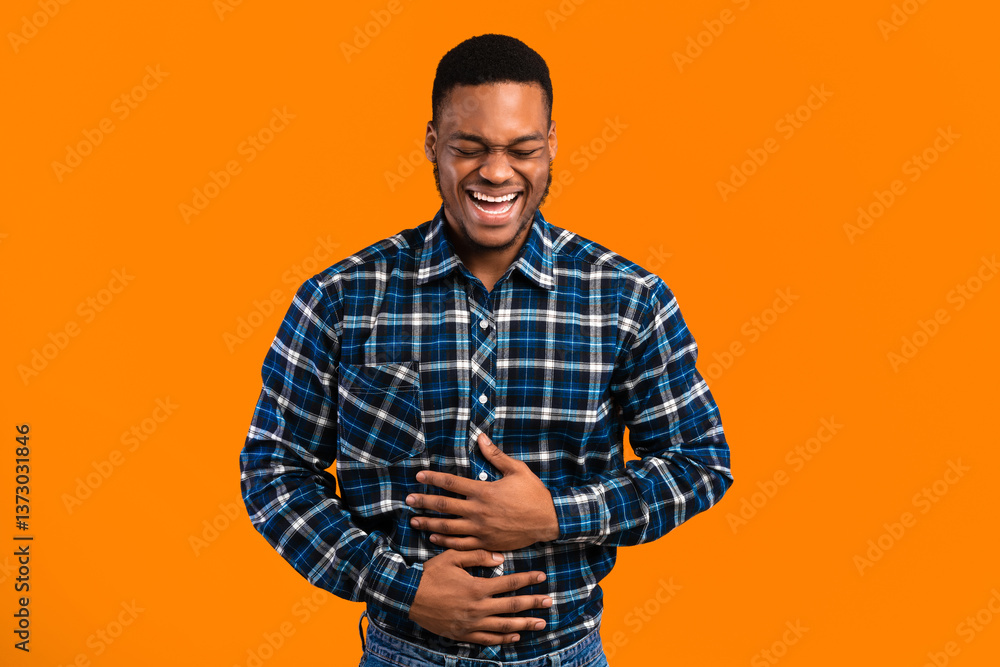 LOL Concept. African Guy Laughing Out Loud Touching Stomach Standing Over Yellow Background. Studio Shot LOL Concept. African Guy Laughing Out Loud Touching Stomach Standing Over Yellow Background. Studio Shot