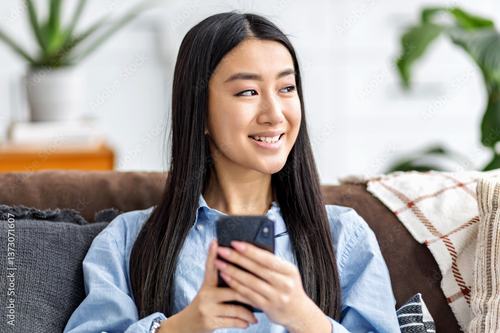 Smiling woman looking away with smartphone
