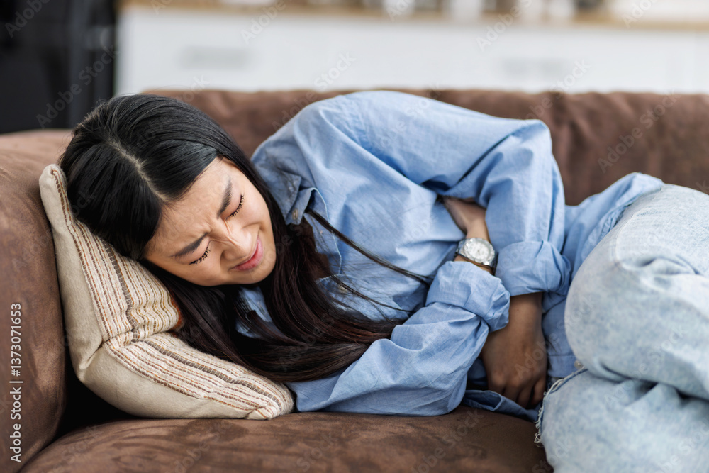 Woman suffering from stomach pain at home