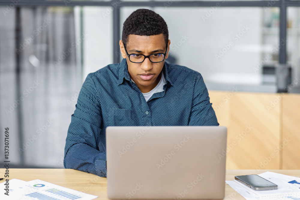 Focused african american man working on laptop