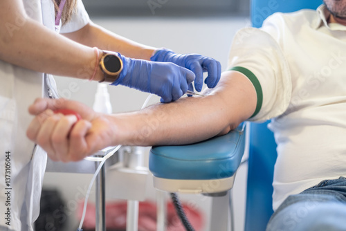 Cuadro en lienzo Anonymous hands of a nurse inserts the needle of the probe to her voluntary patient to start donating blood