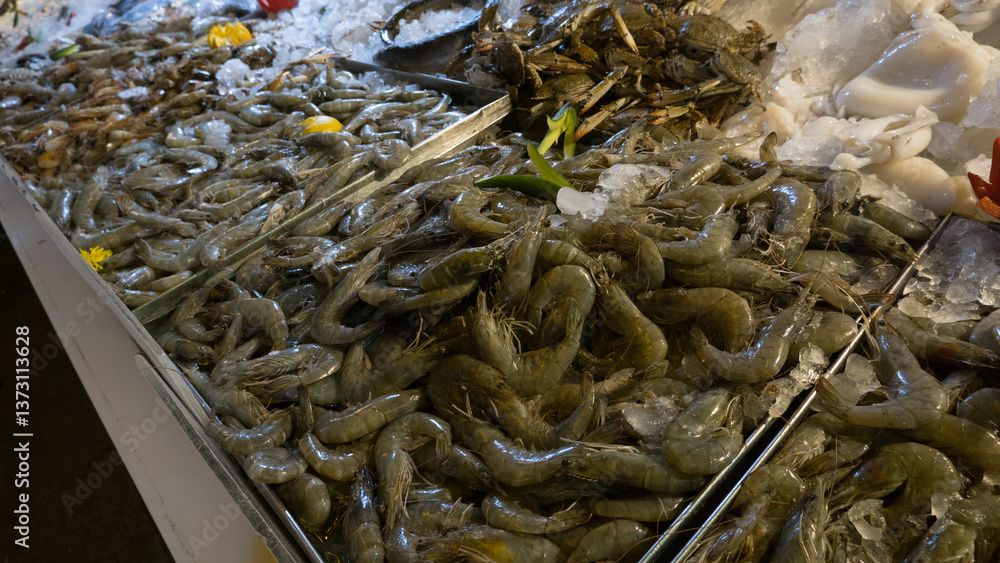 Fresh seafood displayed on ice at a vibrant market, featuring fish, shrimp, crabs, and shellfish, emphasizing oceanic abundance.