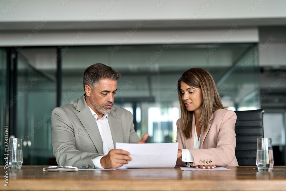 Fototapeta premium Mature business woman manager consulting older man client holding legal documents at meeting. Two professional executives discussing financial accounting papers working together in office.