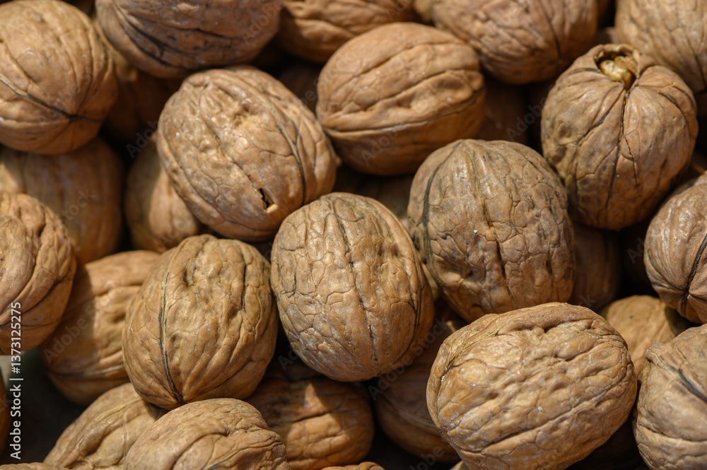 Natural beauty of sun-dried walnuts gathered on a wooden table in a rustic kitchen setting Natural beauty of sun-dried walnuts gathered on a wooden table in a rustic kitchen setting