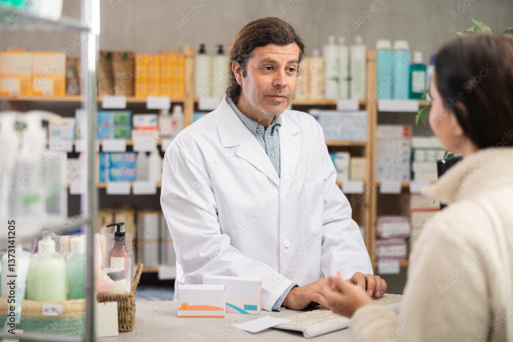 Fototapeta premium Adult man pharmacist looking for medicine on computer for adult woman buyer in pharmacy