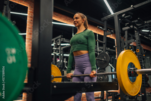 Fényképezés Determined sportswoman lifting barbell, practicing deadlift exercise in modern g