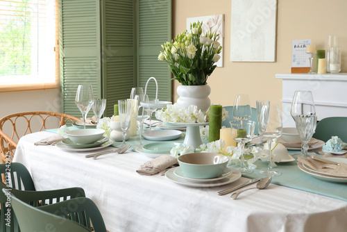 Beautiful table setting with white flowers for wedding celebration in room