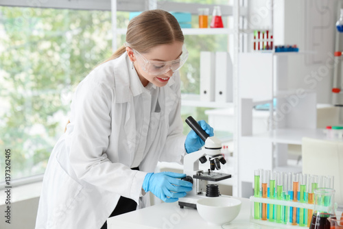 Female chemist with microsc...