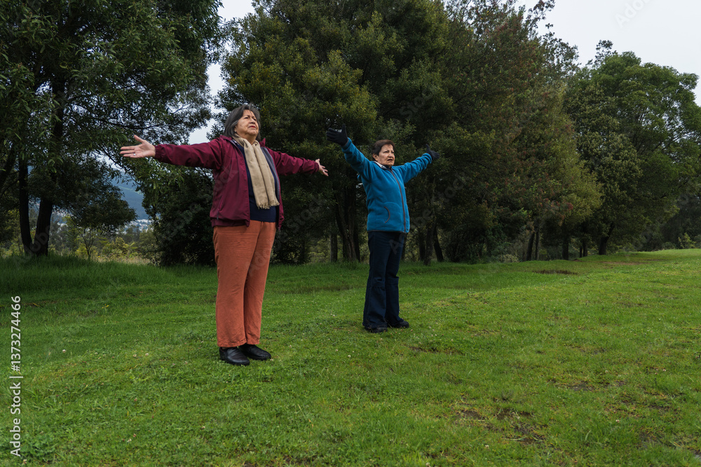 Senior women practicing qigong in a public park, embracing health and wellness. Practicing breathing exercises Senior women practicing qigong in a public park, embracing health and wellness. Practicing breathing exercises