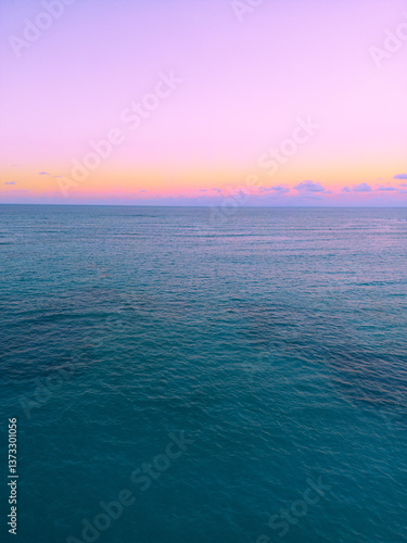 Aerial view of colorful sunset over ocean in Punta Cana.Breathtaking scenery showcases sky painted with stunning hues, while gentle waves reflect evening light. Postcard capturing beauty of tropical