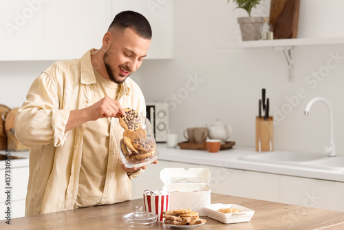 Young man taking cookie fro...