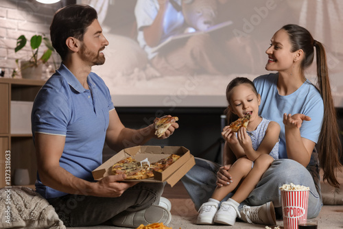 Family with tasty pizza dur...