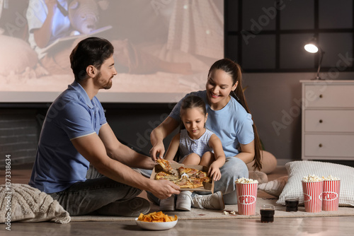 Family with tasty pizza dur...