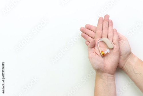 Картината върху платно Woman holding a hearing impairment device in the hands with a white background a
