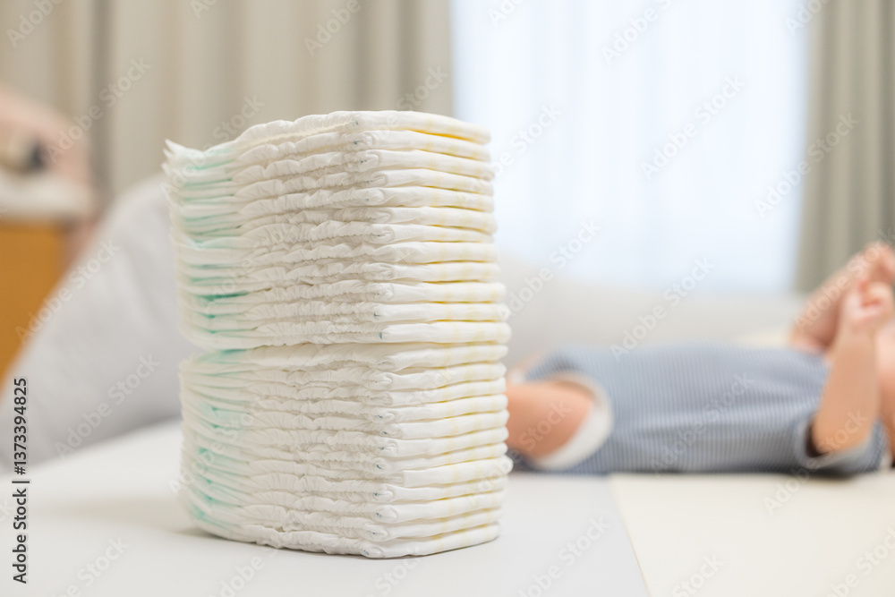 Baby diaper stack with infant resting behind