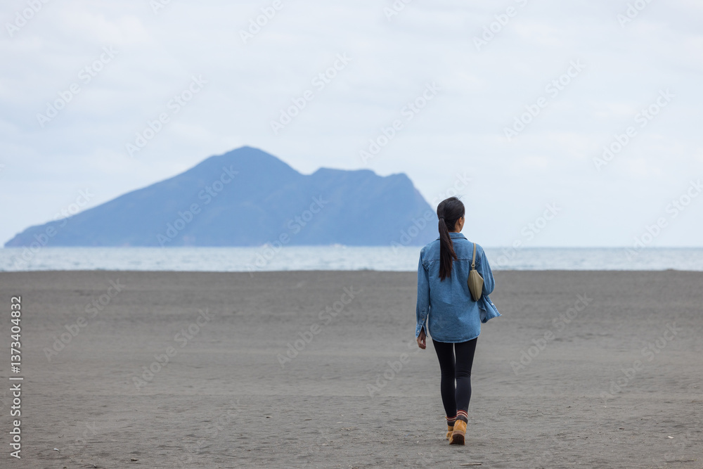 Person Walking Alone on Empty Beach Facing Ocean