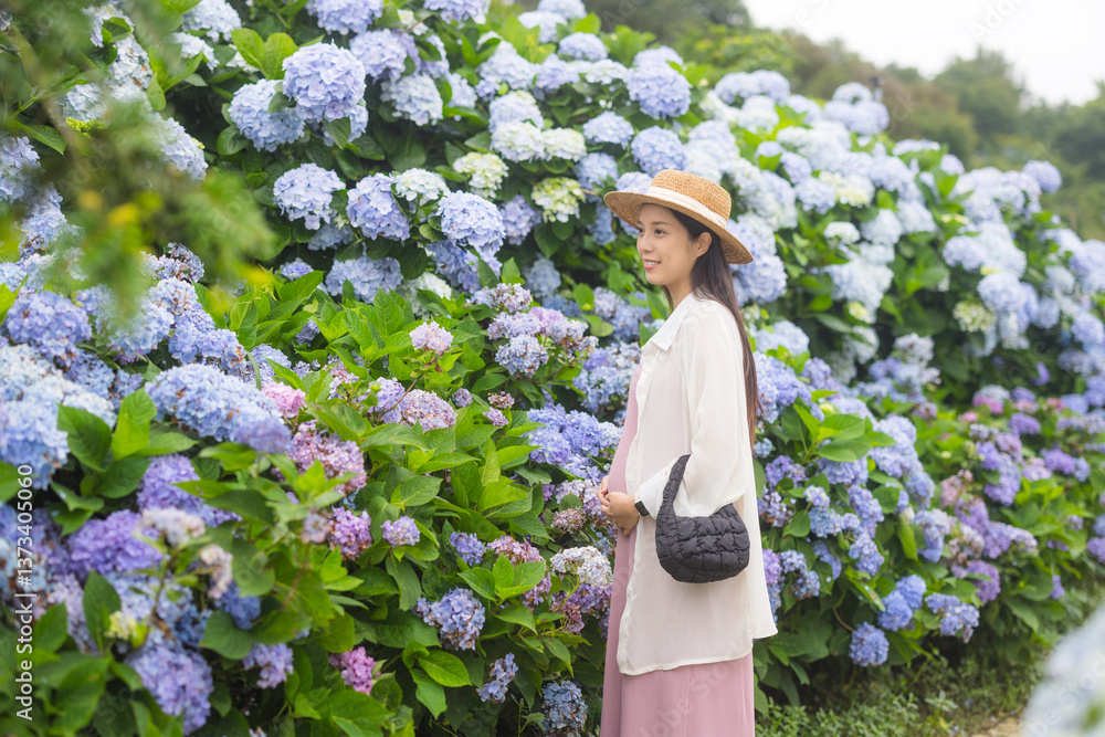 Expecting mother standing in blooming flower field