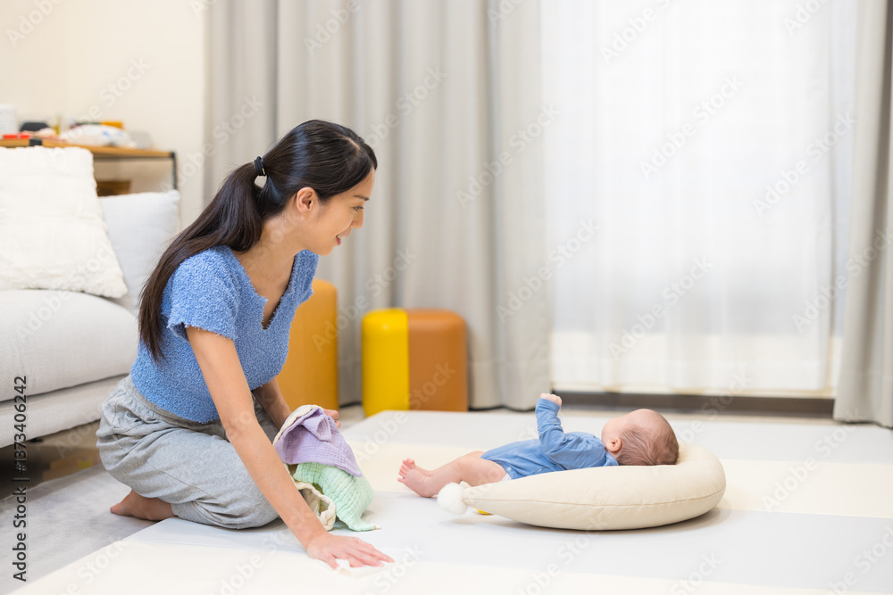 Young mother doing housework with baby
