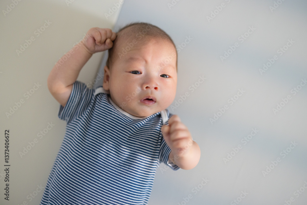 Calm baby lying on soft white background