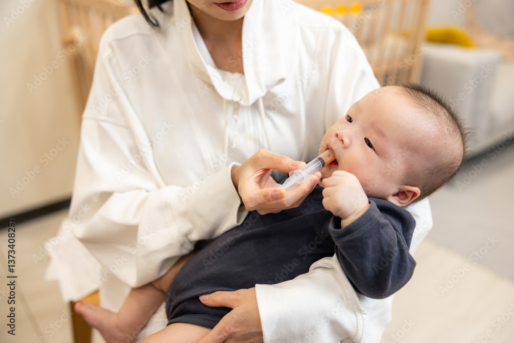 Mom helping baby take medicine with dropper