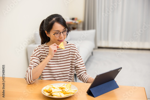 Obraz na płótnie Female enjoying snacks while using tablet at home w salonie