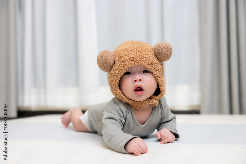 Adorable baby wearing cute bear hat crawling
