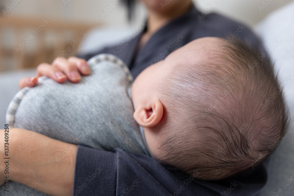 Caring mother soothing newborn baby to sleep