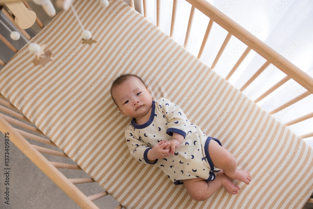 Adorable baby resting in wooden crib peacefully