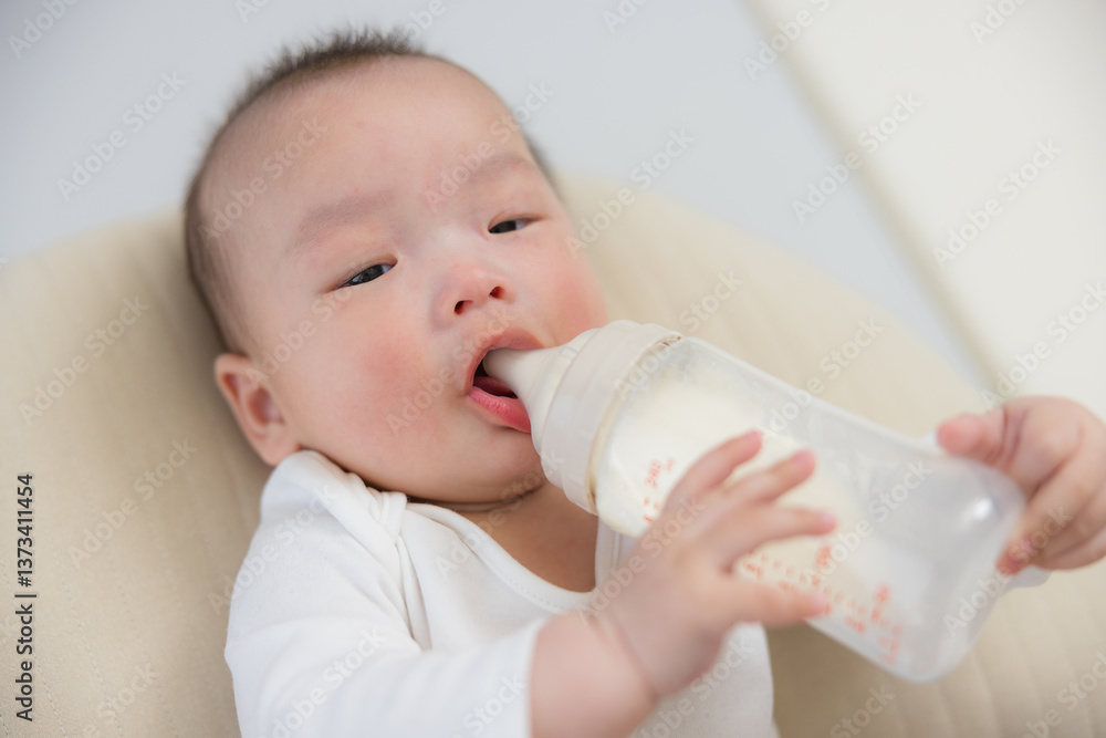 Adorable baby drinking milk from bottle