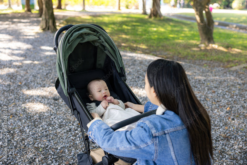 Mother and baby stroller in green park