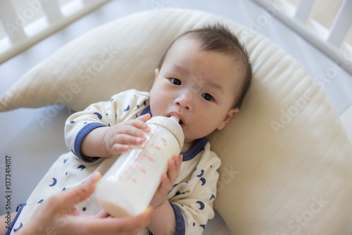 Obraz na płótnie Infant lying on cushion drinking milk w salonie