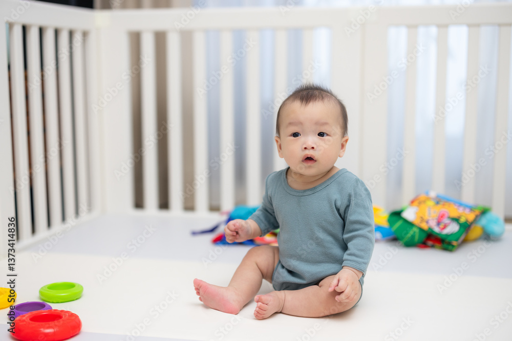 Baby sitting inside crib surrounded by toys