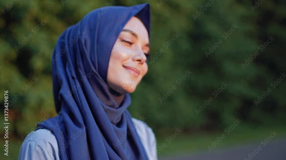 Serene woman in hijab enjoying nature with a peaceful smile Serene woman in hijab enjoying nature with a peaceful smile