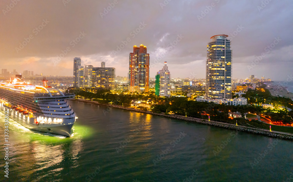 Naklejka premium Cityscape of downtown Miami with sunset glow. Tropical paradise in South Beach. Midnight city lights in Miami. Waterfront view of Miami skyline. Aerial shot of Miami at sunrise. Neon Art Deco. Ocean