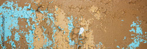 Obraz na płótnie Peeling paint on the wall. Panorama of a concrete wall with old cracked flaking paint. Weathered rough painted surface with patterns of cracks and peeling. Wide panoramic grunge texture for background w salonie