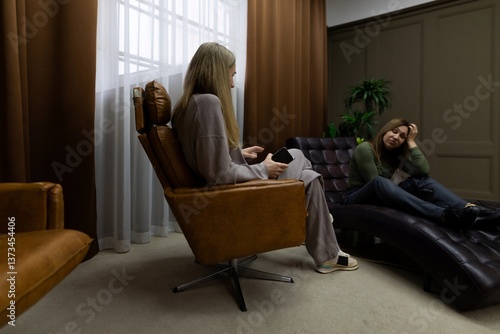 Принти на полотні Two women engaged in serious conversation in a cozy room with modern decor and t