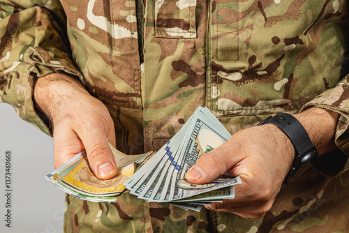 Soldier counting cash in military uniform at a neutral location